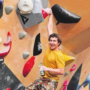 «Für immer und ewig» - Er kann sogar einhändig (mit Bier) in der Kletterwand hängen. Kevin Huser in seiner Kletterhalle «Bouba» in Baden. Bild: zg