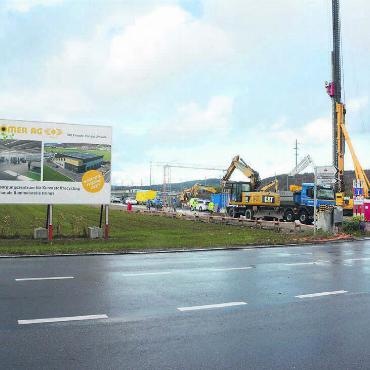 So macht Abfall trennen mehr Spass - Direkt neben der Nutzenbachstrasse wird mit Hochdruck an der neuen Sammelstelle gearbeitet. Dabei kommt die schweizweit grösste Maschine für Pfählungen zum Einsatz. Bild: Chregi Hansen / Visualisierung: zg