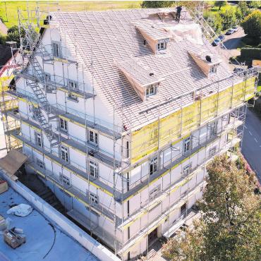 Schwieriger als angenommen - Das Gemeindehaus wurde für die aktuellen Arbeiten komplett eingerüstet. Bild: zg