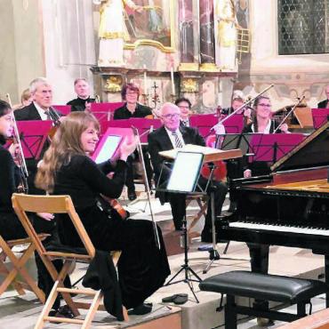 Wunderbares Klassikkonzert - Pianistin Sophie Holma und Dirigent Renato Botti umarmen sich nach getaner Arbeit. Glücklich nimmt das Orchester den wohlverdienten Applaus des Konzertpublikums entgegen. Bild: aha