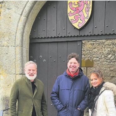 «Zu den Wurzeln unserer Dynastie» - Leopold Altenburg und Sabine Stadler mit Rudolf Velhagen (links), Chefkurator des Museums Aargau, vor dem Schloss Habsburg. Am Eingang prangt das ursprüngliche Habsburger Wappen. Bild: pd