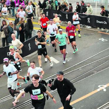 Feuchte Socken, trockener Humor - Im Rampenlicht: Manuel Meier (unten) wird während des Marathons von einem Animator mit Megafon motiviert. Bilder: zg