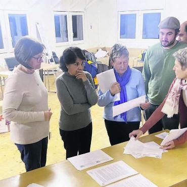 Nachhaltigkeit und Integration - Koordinator des Repair-Cafés Mutsch Saravana Voellmy (mit Mütze) ist vom Engagement der freiwilligen Helferinnen und Helfer begeistert. Gemeinsam wird die Organisation des ersten Reparaturevents in Widen besprochen. Bild: Sabrina Salm
