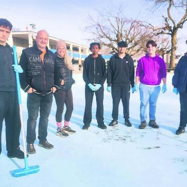Die Badi herausputzen - Die 15-Jährigen (blaue Handschuhe) von Klassenlehrerin Petronella Bamert (3. v. l.) helfen dem Team von Badileiter Roger Marti (2. v. l.) unter anderem beim Schrubben der Badebecken. Bild: Marco Huwyler
