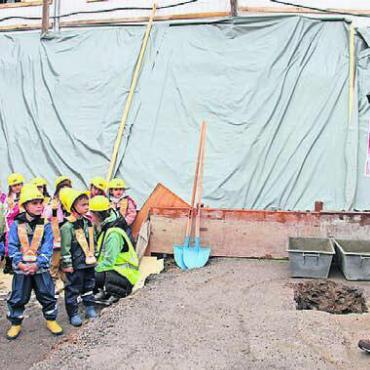 Baustelle gleich vor der Tür - Schulleiter Andrea Nauli erklärt den Kindern, was mit ihren Zeichnungen nun passiert.