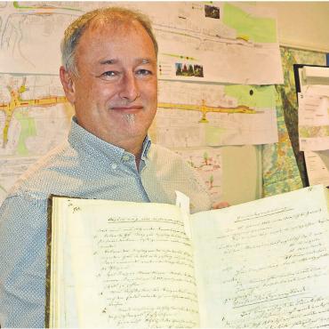 Freude am Steuern - Gemeindeammann Roger Hausherr zeigt ein Gemeinderatsprotokoll von 1857. Für ihn ist das ein Symbol dafür, seine Arbeit mit einer gewissen Gelassenheit zu nehmen. «Ich bin nicht der erste Eggenwiler Gemeinderat und werde auch nicht der letzte sein», relativiert er. Bild: Roger Wetli