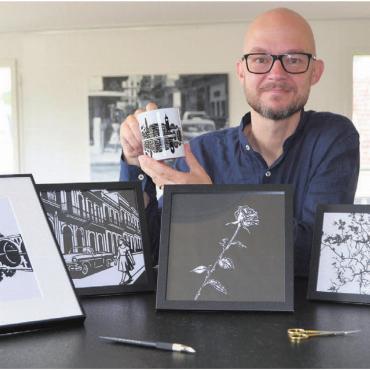 Das Spiel mit Licht und Schatten - Scherenschnitt ist Markus Eichhorns Leidenschaft. Sein Werk der Bremgarter Skyline bedeutet ihm viel – auch auf Tassen ist es gedruckt. Bild: Sabrina Salm