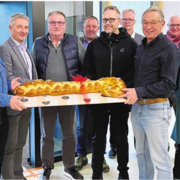 Der Schlüssel ist übergeben - Symbolischer Zopfschlüssel: Die Beteiligten freuen sich gemeinsam über die Fertigstellung des Grossprojekts. Bild: zg