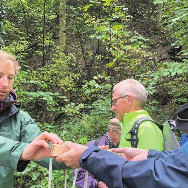 «Der Wald braucht uns nicht» - Der Waldexperte Maurus Landolt (links) verteilte Eschenstammscheiben an Interessierte. Bild: gum