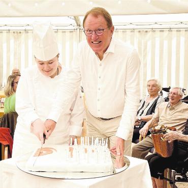 Ein jung gebliebenes Zuhause - Fröhliche Gesichter zum süssen Jubiläum. Verbandspräsident Peter Spring durfte am Samstag die hausgemachte Torte anschneiden. Bild: Walter Minder