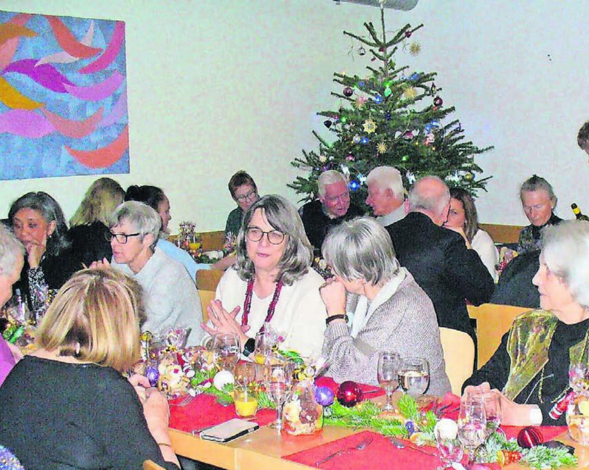 Ein Blick auf die fröhliche Gästerunde der Weihnachtsfeier in der Synesiusstube mit dem traditionellen Christbaum und der liebevoll gestalteten Tischdekoration. An Heiligabend ist hier jeder willkommen. Der Pastoralraum knüpft mit der Feier an das langjährige Angebot im einstigen Centro Italiano von Armando Caravetta an. Bild: Alphonse Hauser