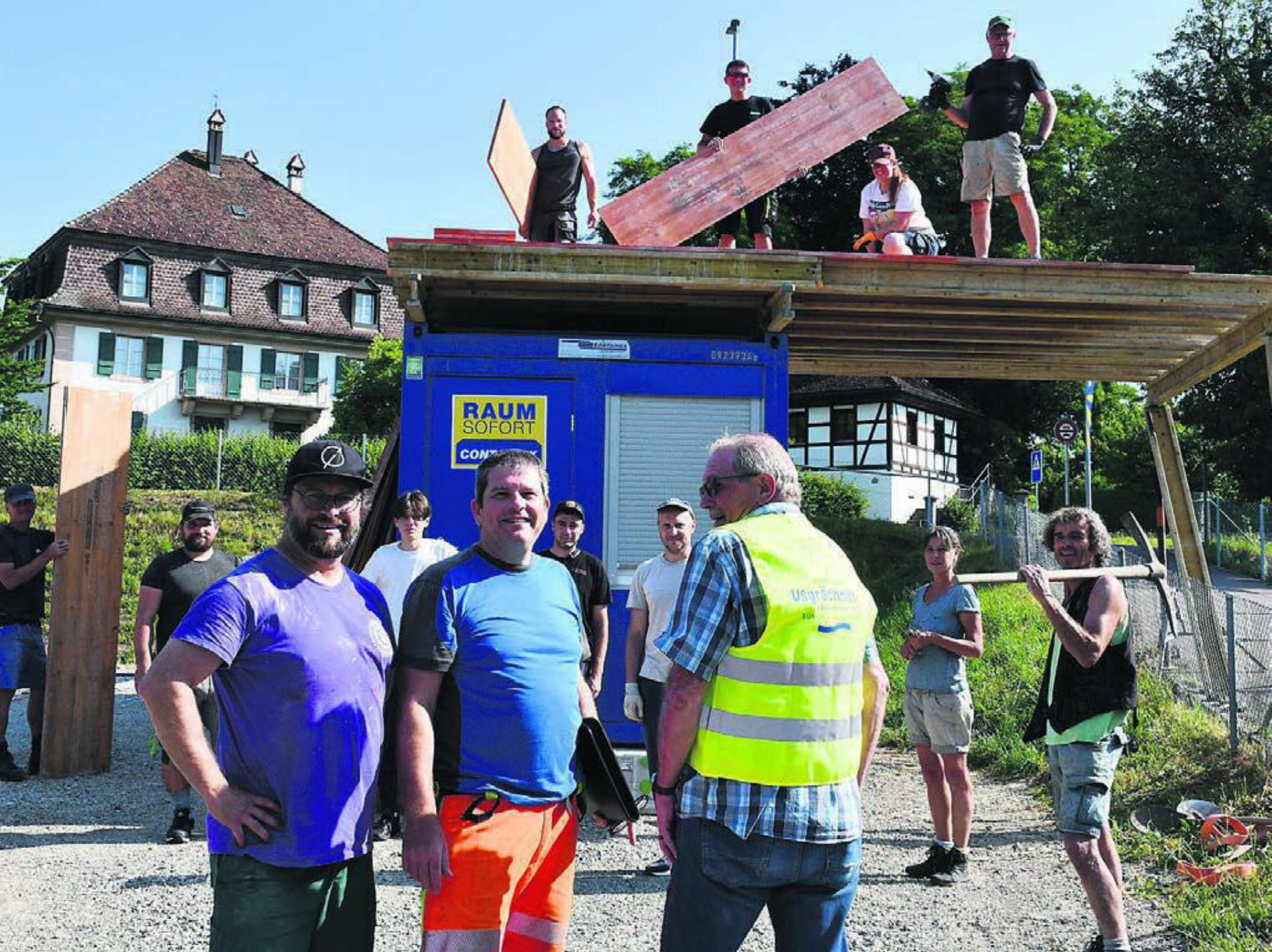 Das OK und die Helfer sind voll motiviert. Trotz Sonne und warmen Temperaturen sind sie auch für einen kurzen Fotostopp bereit. Vorne in der Mitte präsentiert OK-Präsident Ruedi Seiler das Gilet mit passendem Fest-Aufdruck. Bilder: Verena Anna Wigger