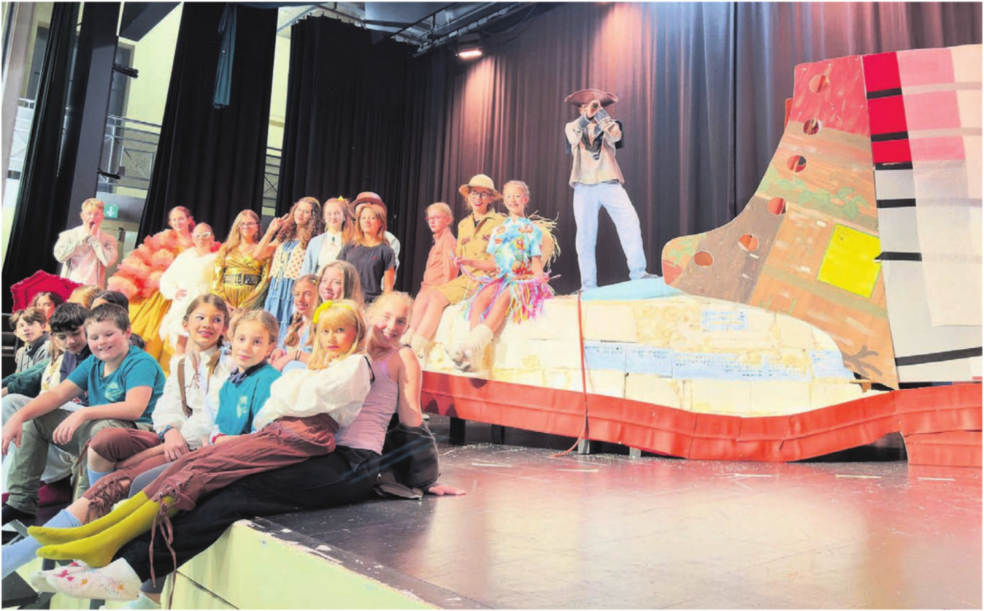 Ein riesiger Schuh steht im Zentrum des Bühnenbildes. Um und auf diesem wird Gullivers Reisen  aufgeführt. Bild: zg - Das Bild wird blockiert. – Möglicherweise durch einen aktiven Adblocker.