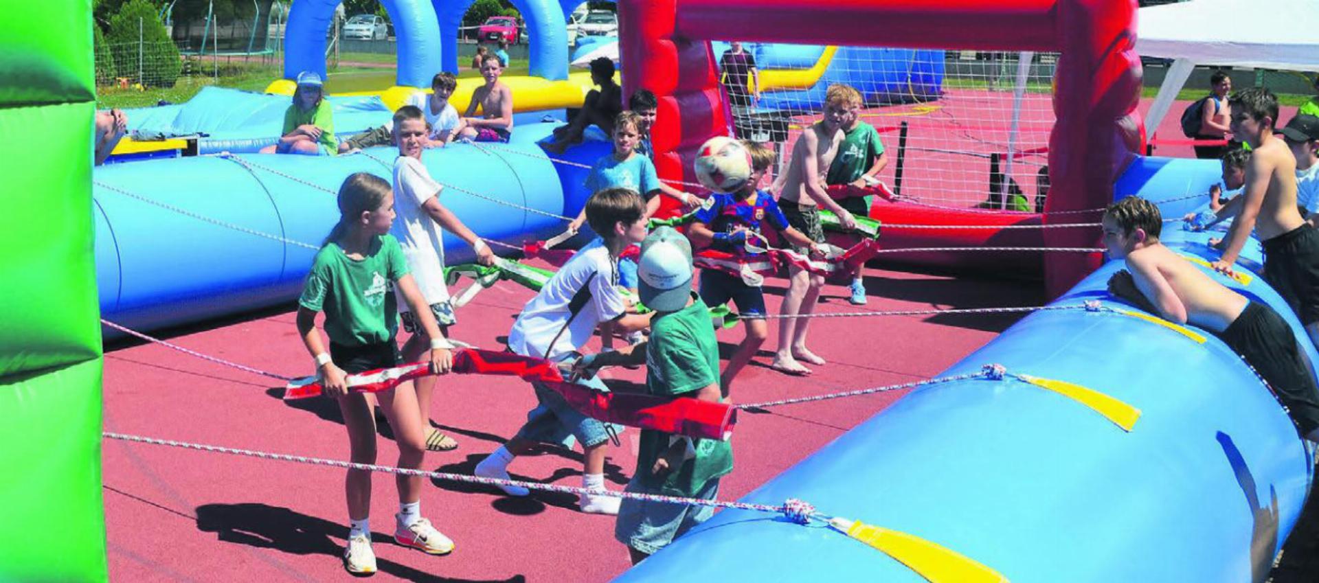 Die Kinder messen sich mit grossem Einsatz im «Menschen-Kicker», dem Turnier im Riesen-Töggelikasten. Bilder: Thomas Stöckli / zg