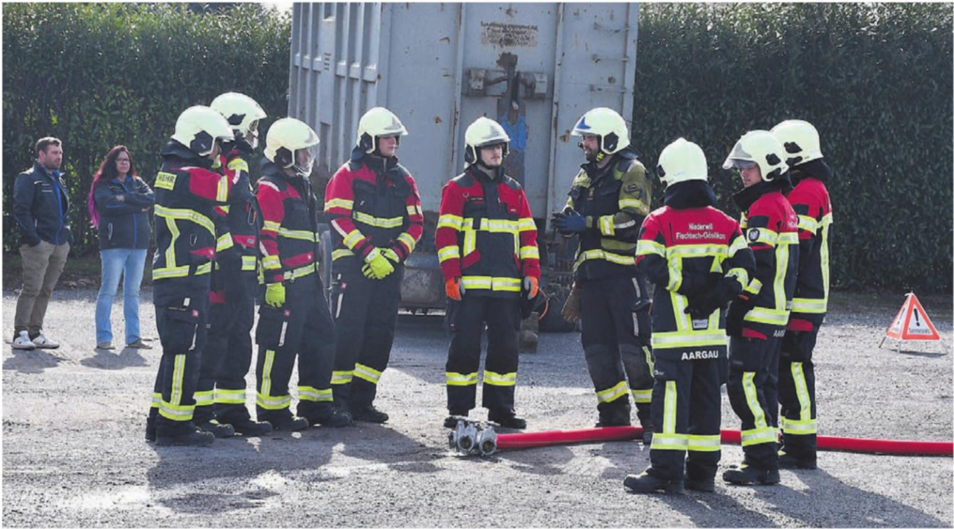 Klassenlehrer Florian Berger, in der Mitte mit dunklem Anzug, instruiert die Gruppe von angehenden Feuerwehrleuten. Sie hören aufmerksam zu, bevor sie in Aktion treten. Denn überlegtes Handeln ist einer der Leitsätze, welche die Feuerwehr in ihrem Handwerk anstrebt. Bilder: Verena Anna Wigger - Das Bild wird blockiert. – Möglicherweise durch einen aktiven Adblocker.