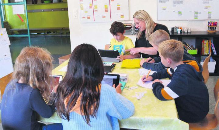 Recherchieren, notieren und besprechen: Die 3.-Klässler nehmen sich in den Projektstunden neuer Herausforderungen an. Ihr erstes Projekt ist eine Schülerzeitung. Lehrerin Sonja Ryser begleitet sie dabei. Bild: Sabrina Salm