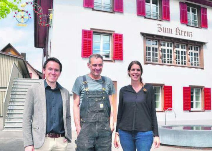 Unter dem Wirtshausschild auf dem Dorfplatz: Gemeindeschreiber Lorenz Staubli mit Kunstschlosser Werner Villiger und Gemeinderätin Julia Huber (von links). Bild: Thomas Stöckli