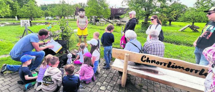 Autor Stefan Sprenger liest die Murimoos-Geschichte aus dem Kinderbuch vor. Kinder, Eltern und Chnorrlimorrli hören gespannt zu.