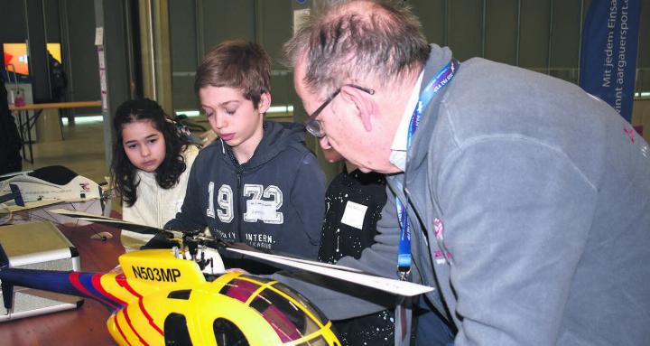 «Ein Helikopter ist aufwendiger zu steuern als ein Modellflugzeug», weiss der Helfer. Lisa und Hannes versuchen es trotzdem. Bild: Erika Obrist