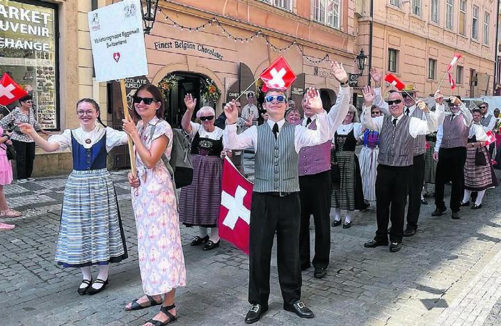 Die Volkstanzgruppe Eggenwil verschenkte während des Umzugs die mitgebrachten Schweizer Fähnchen den Passanten. Bild: zg