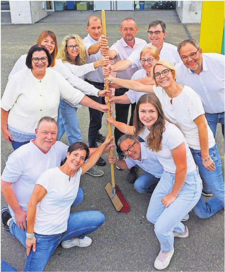 Mottotreu greift das OK zum Besen. Am Stiel von unten: André Käppeli, Urs Schneebeli, Steffi Sprenger, Lisa Heggli, Präsidentin Claudia Dober, Vreni Sidler, Rebi Schwitter, André Konrad, Simone Meier, Kari Suter, Nici Steiner, Beni Niederer und Roger Klausner.
