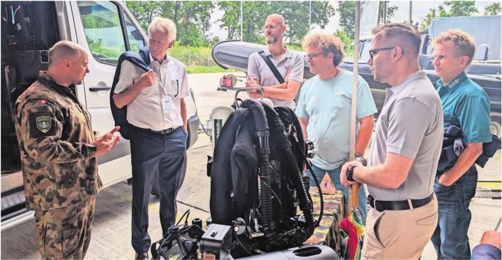 Michael Schnyder, Leiter der Bremgarter Armeetaucher, erklärt dem Stadtammann und weiteren Interessenten die Besonderheiten seiner Truppengattung. Bild: Marco Huwyler