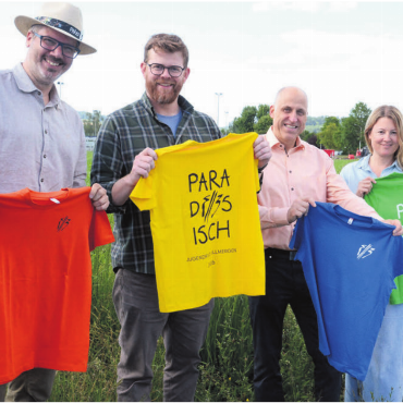 Dem Dorf etwas schenken - So farbenfroh wie die Fest-T-Shirts der Kinder sollen die drei Tage werden. OK-Chef Philippe Wyser, Umzugschef Patrick Hilfiker, Schulleiter Iso Kalchofner und Presse-Chefin Sandra Donat (von links) sind überzeugt, dass dies gelingt. Bild: Chregi Hansen