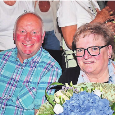 Blumiger Abend in der Aula - Fast zwanzig Jahre lang haben Ferdi und Ingrid Koller die Schulanlage Falter tadellos in Schuss gehalten. An der «Gmeind» wurden sie mit Standing Ovations verabschiedet . Bild: Erika Obrist