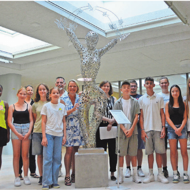 Symbol des Wandels - Künstlerin Evelyne Brader-Frank (links neben der Skulptur) und Schulleiter Florian Stähli (6. v. l.) weihten das Kunstwerk zusammen mit Lehrern und Schülern ein. Bild: rwi