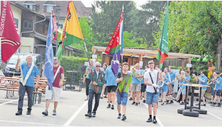 Unterstützt durch die Klänge des Musikvereins ziehen die Fahnenträger der verschiedenen Vereine auf das Festgelände. Die Gemeinde kann sich über sehr aktive Vereine freuen.